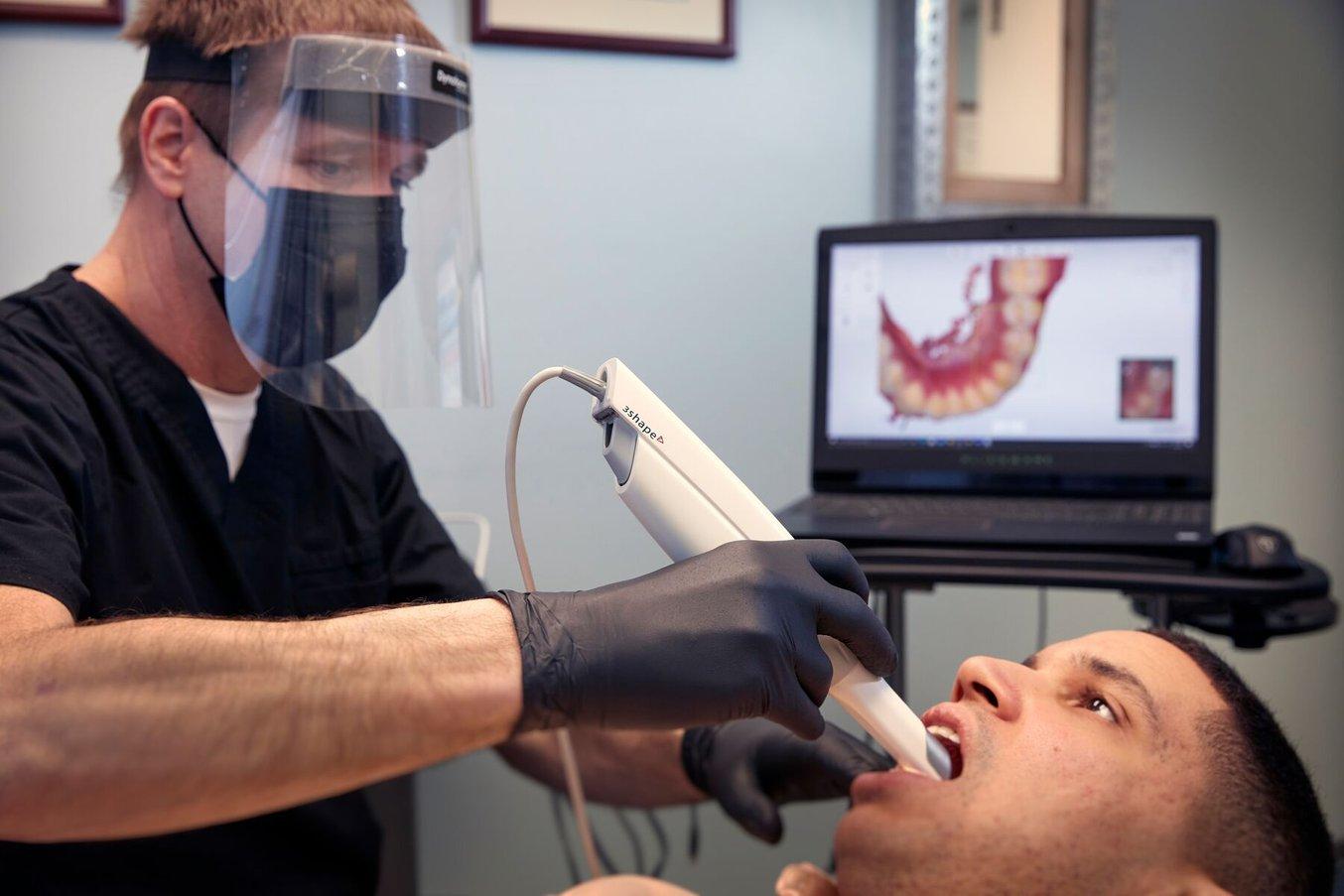 Dental professional using an intraoral scanner on a patient