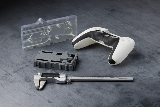 3D printed parts in clear, grey, black, and white resins