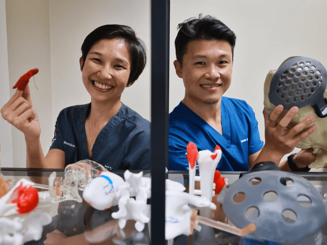 Two doctors holding 3D printed medical devices
