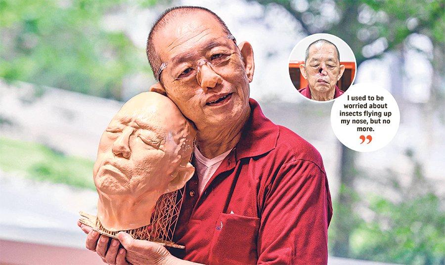 Man holding 3D printed model of his head