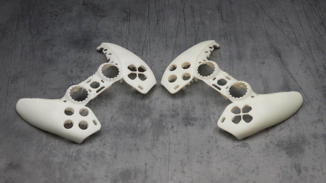 Two prototypes of gaming controllers, a brighter white one on the left and a yellower one on the right