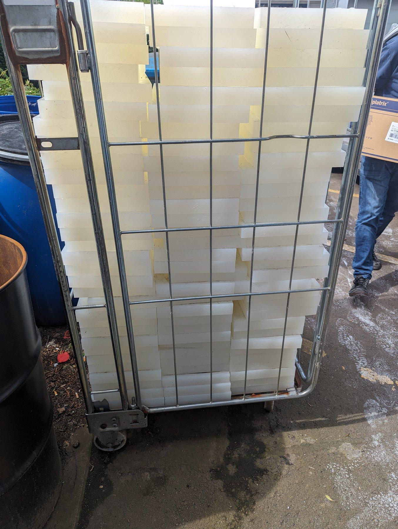 A metal bin filled with blocks of polypropylene from manufacturing insoles