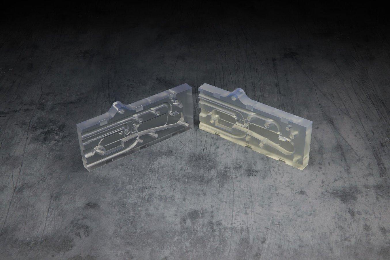 Two clear parts of a mold. The one on the left is clearer and more transparent, the one on the right is more yellowy
