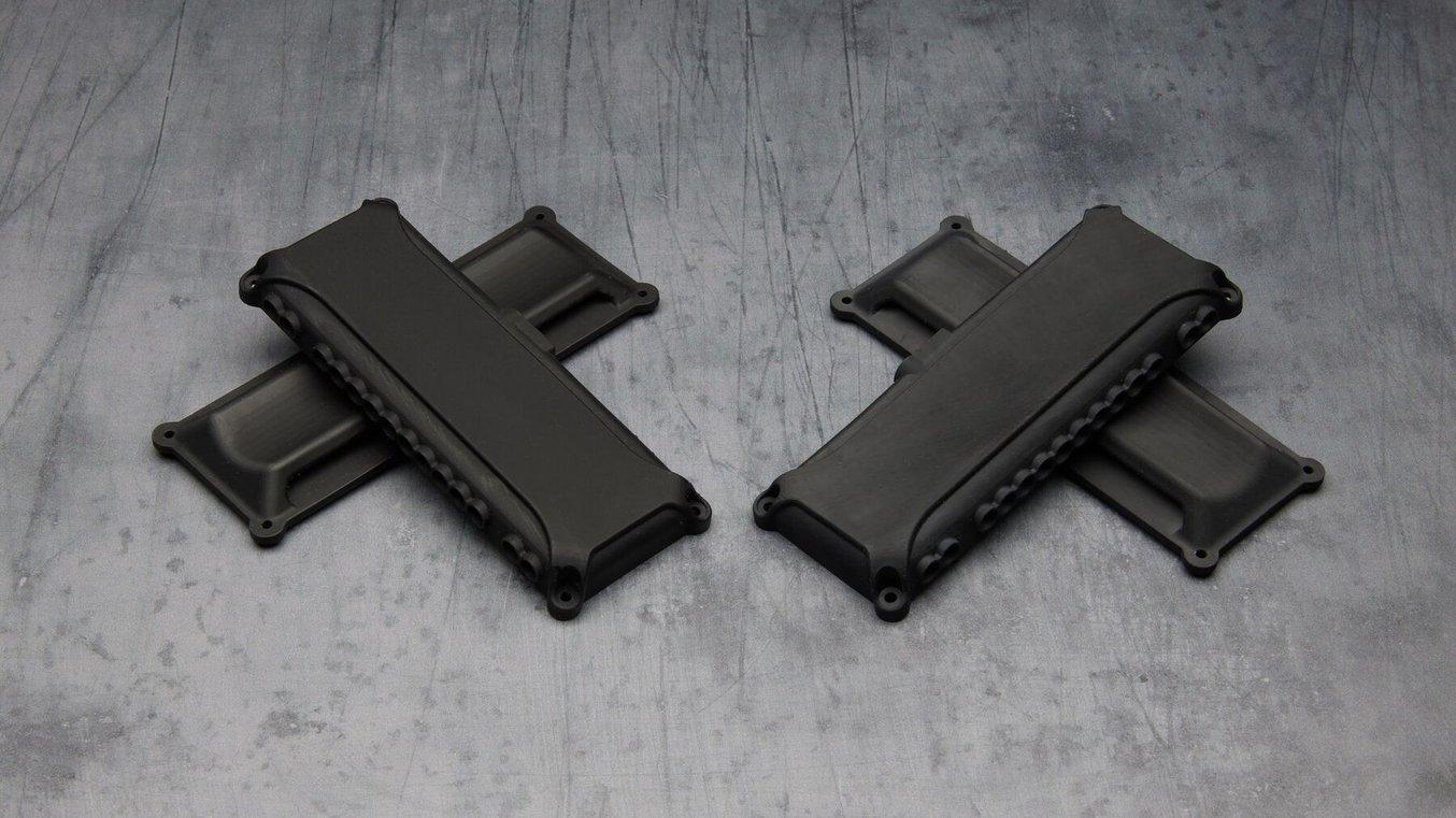 3D gedruckte schwarze Teile. Die Teile links sind farblich satter und matter.