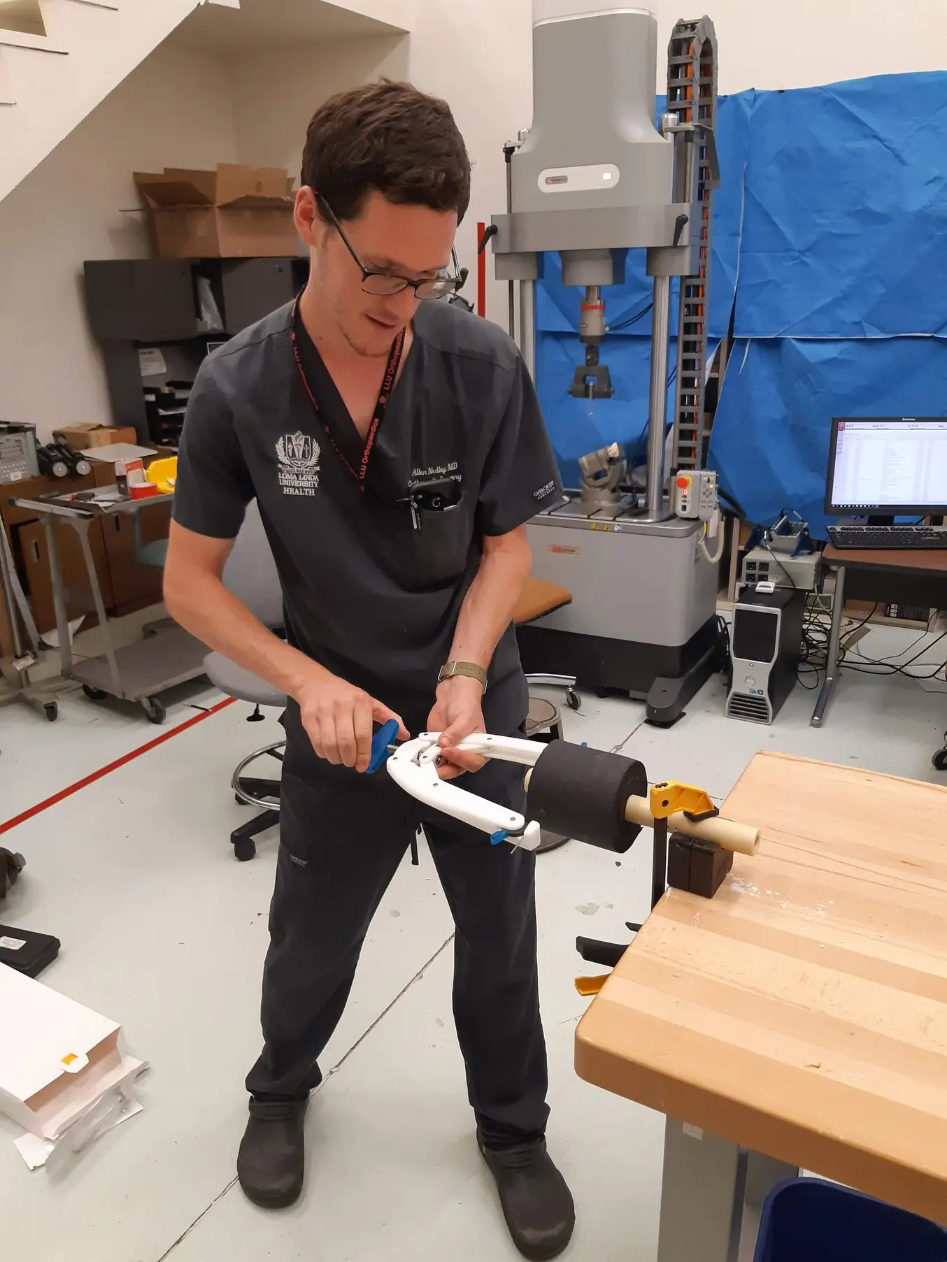 A surgeon performing a strength and usability test on a QuikBow prototype