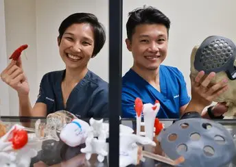 Two doctors holding 3D printed medical devices