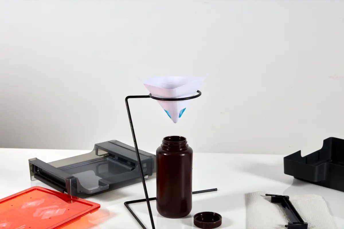 つるすリングスタンドが付いた不透明なプラスチックの容器、その上二吊るすレジンを含む塗料フィルタとForm 3のレジンタンク。