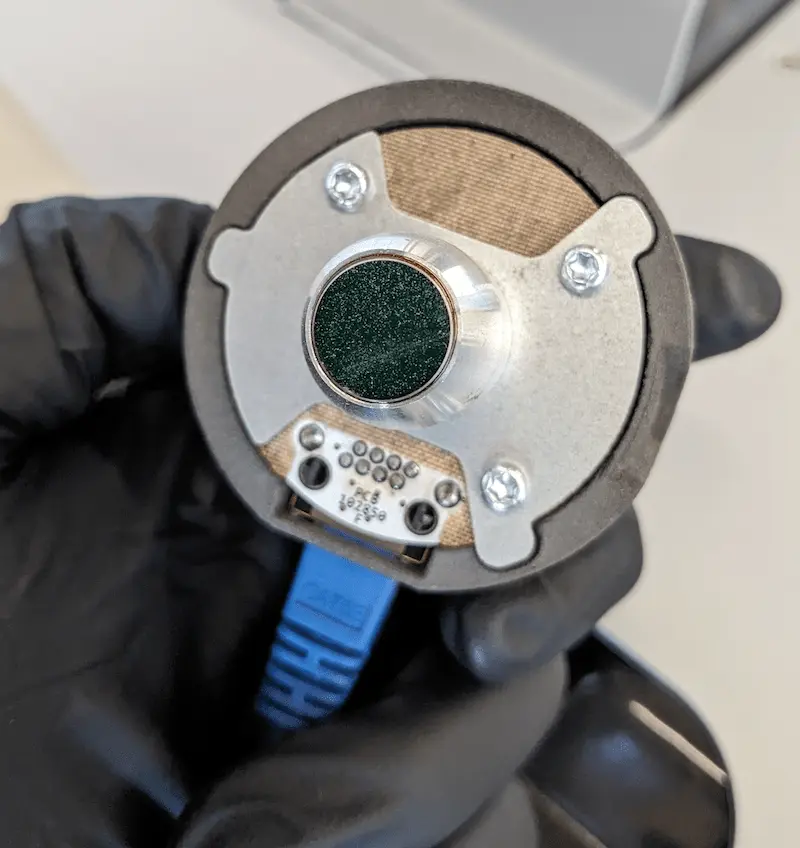 The IR sensor is held so that the opening and lens are clearly visible.