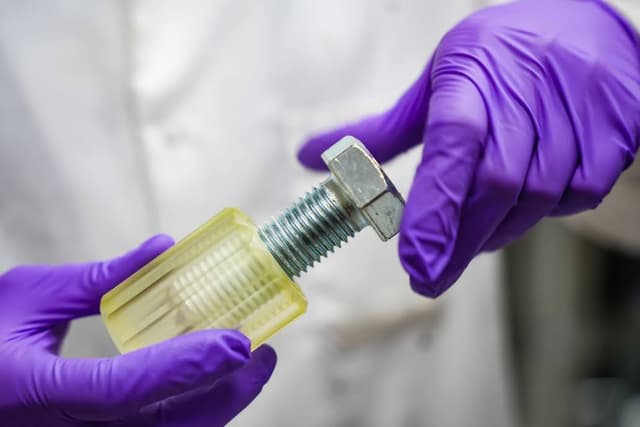 figure engineering's Resist Resin being used to help mask a large bolt during electroplating