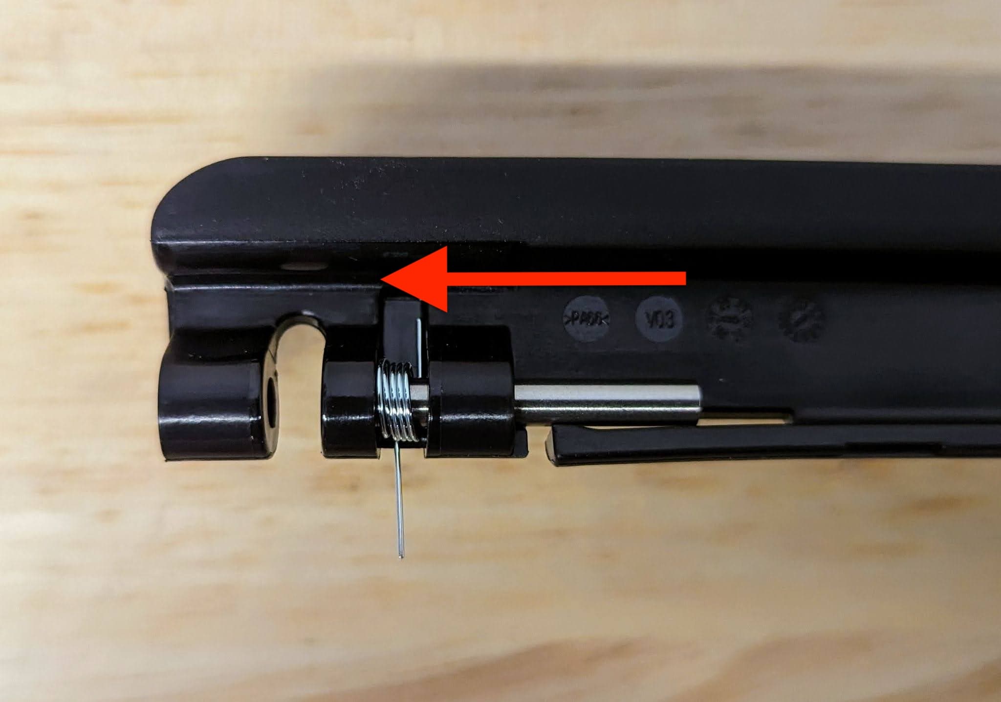 Slide the metal pins into the bracket from the inside of the latch.