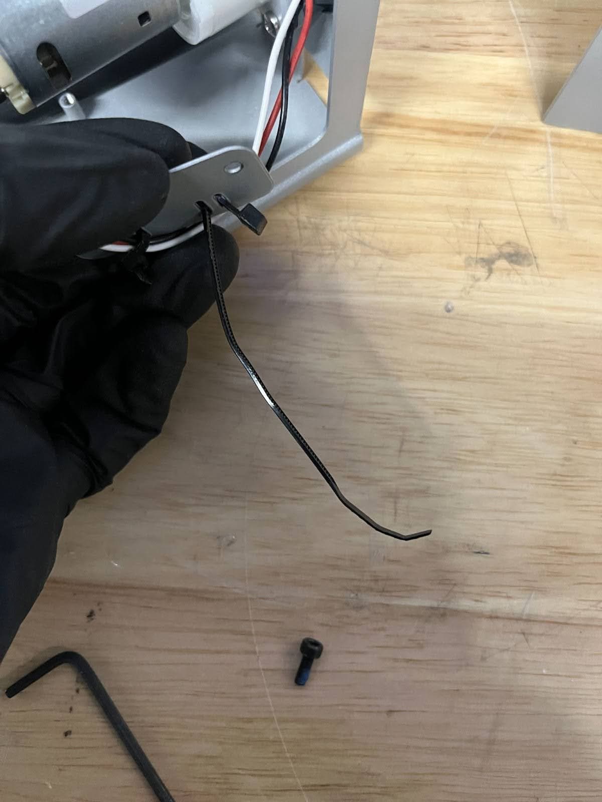 Insert the tip of the zip tie into the head and pull until it engages, leaving a large loop in the zip tie.