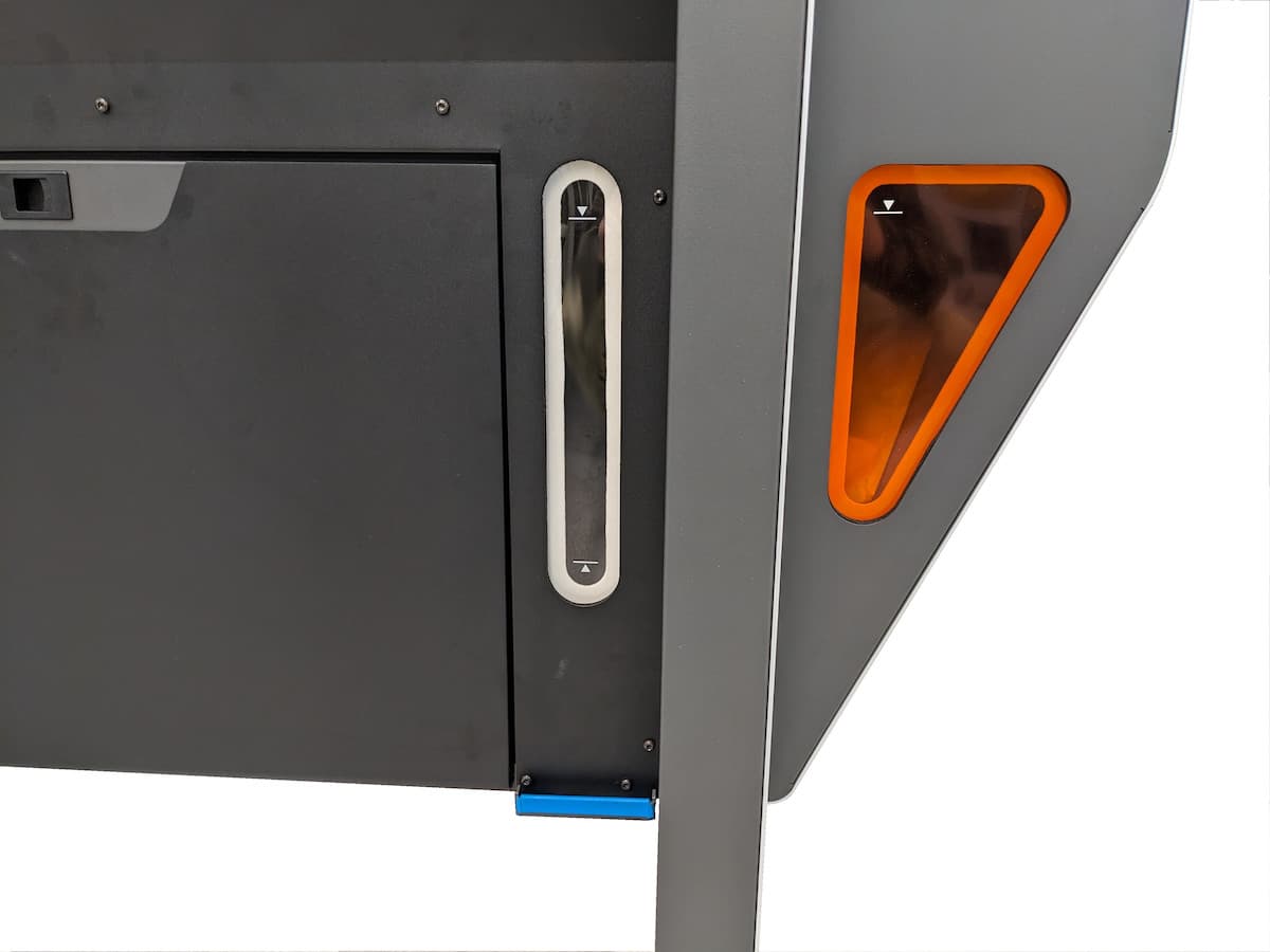 A closeup of the clear media hopper window and the orange waste hopper window