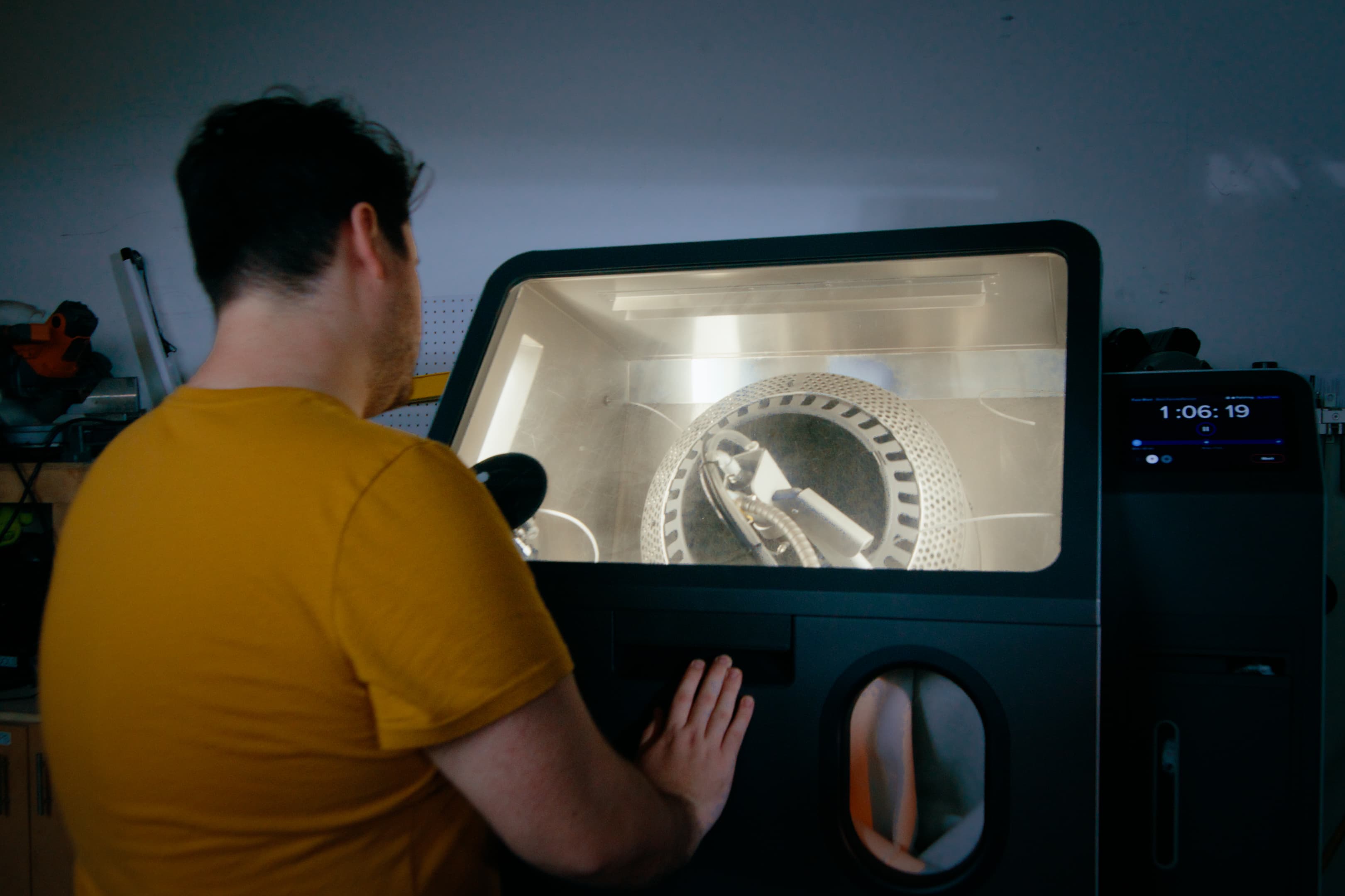Engineer inspecting a post-processed SLS printed component next to a Formlabs Fuse Blast system.