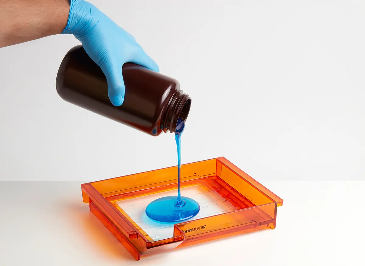 濾過されたレジンを不透明なプラスチックの容器からForm 2のレジンタンクに戻します。