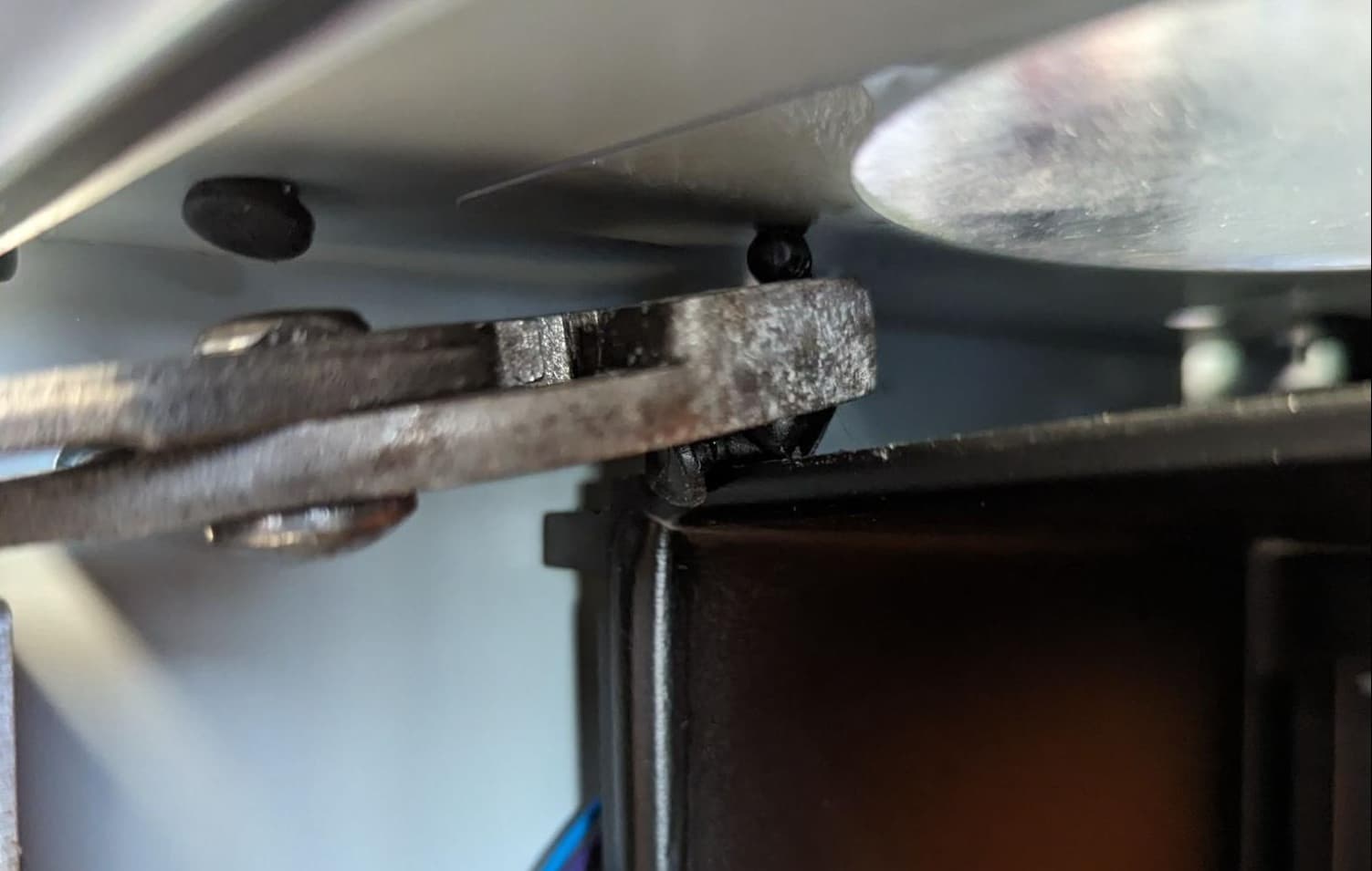 Inserting the upper LPU fan mounting pin with pliers