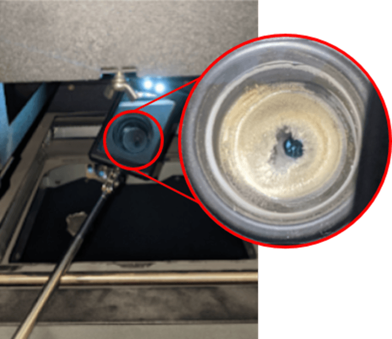 A telescoping mirror is being inserted into the print enclosure to tilt upward. The image in the mirror is annotated and zoomed in to show that the IR sensor housing is obstructed by laurolactam