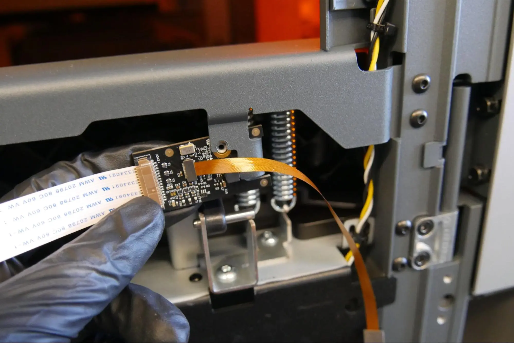 Align the screw hole in the camera board with the slot in its mount on the printer.