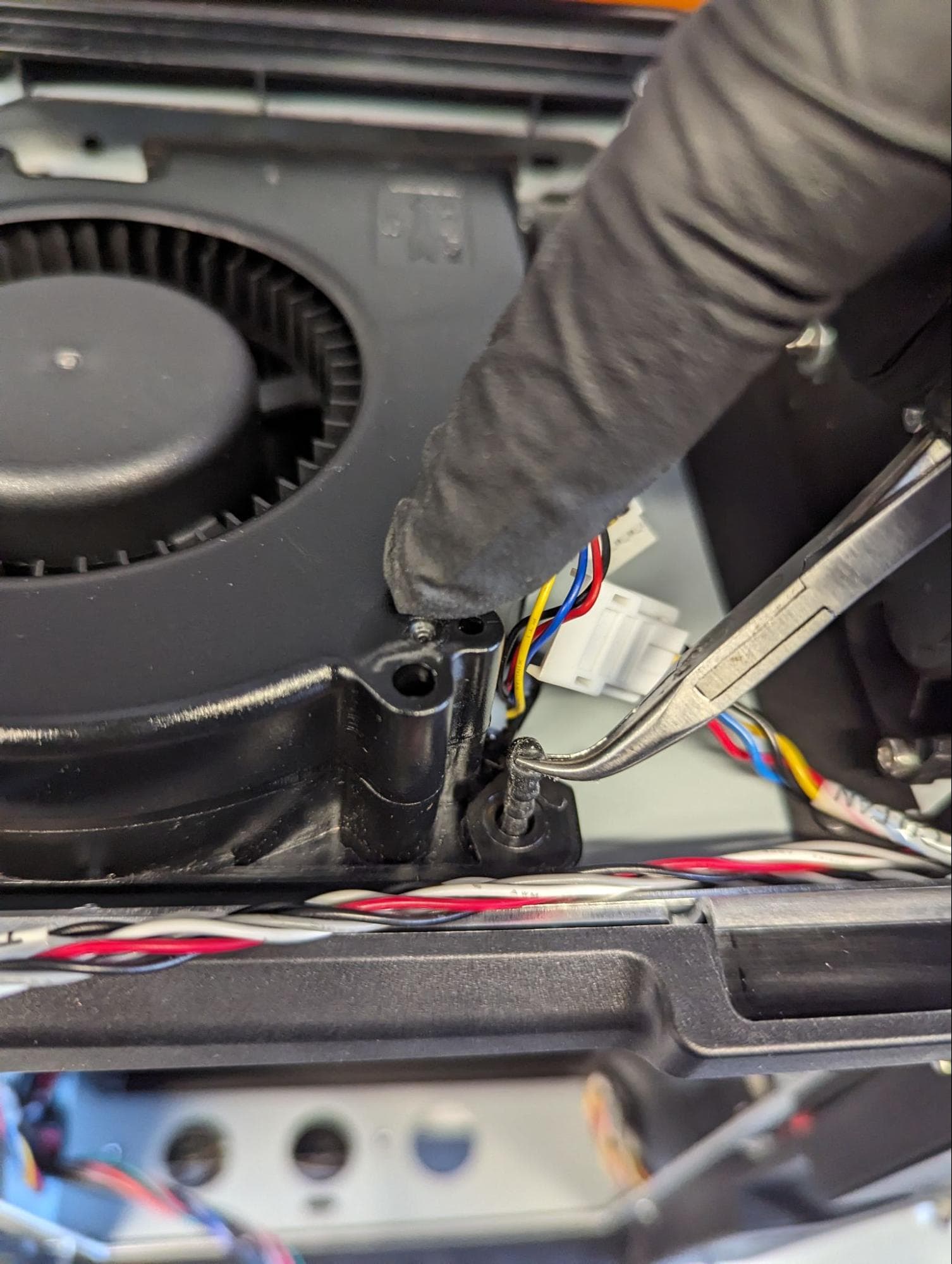 Using needle nose pliers to pull LPU fan mounting pins into position