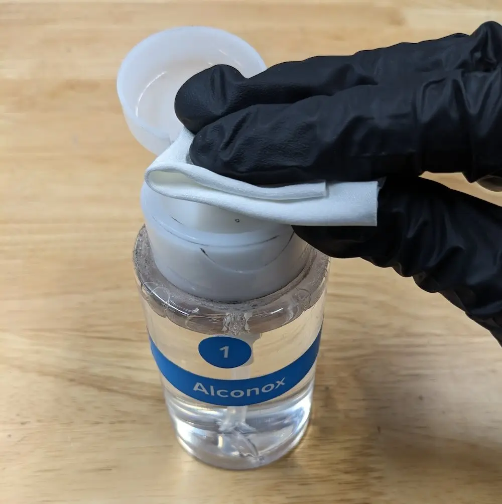 Wetting a cleaning cloth with Alconox