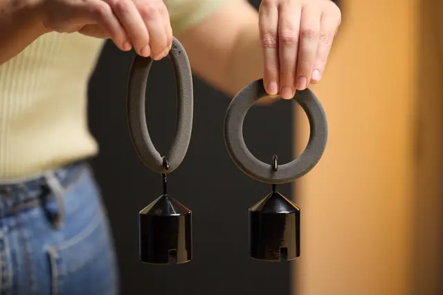 two TPU sls 3D printed loops being weighted down by small weights, showing the variable durometer of the TPU material