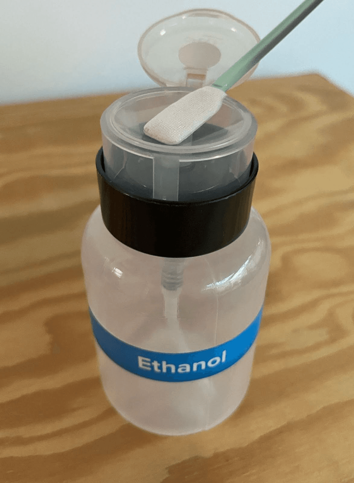 A swab is being held against the top of a bottle