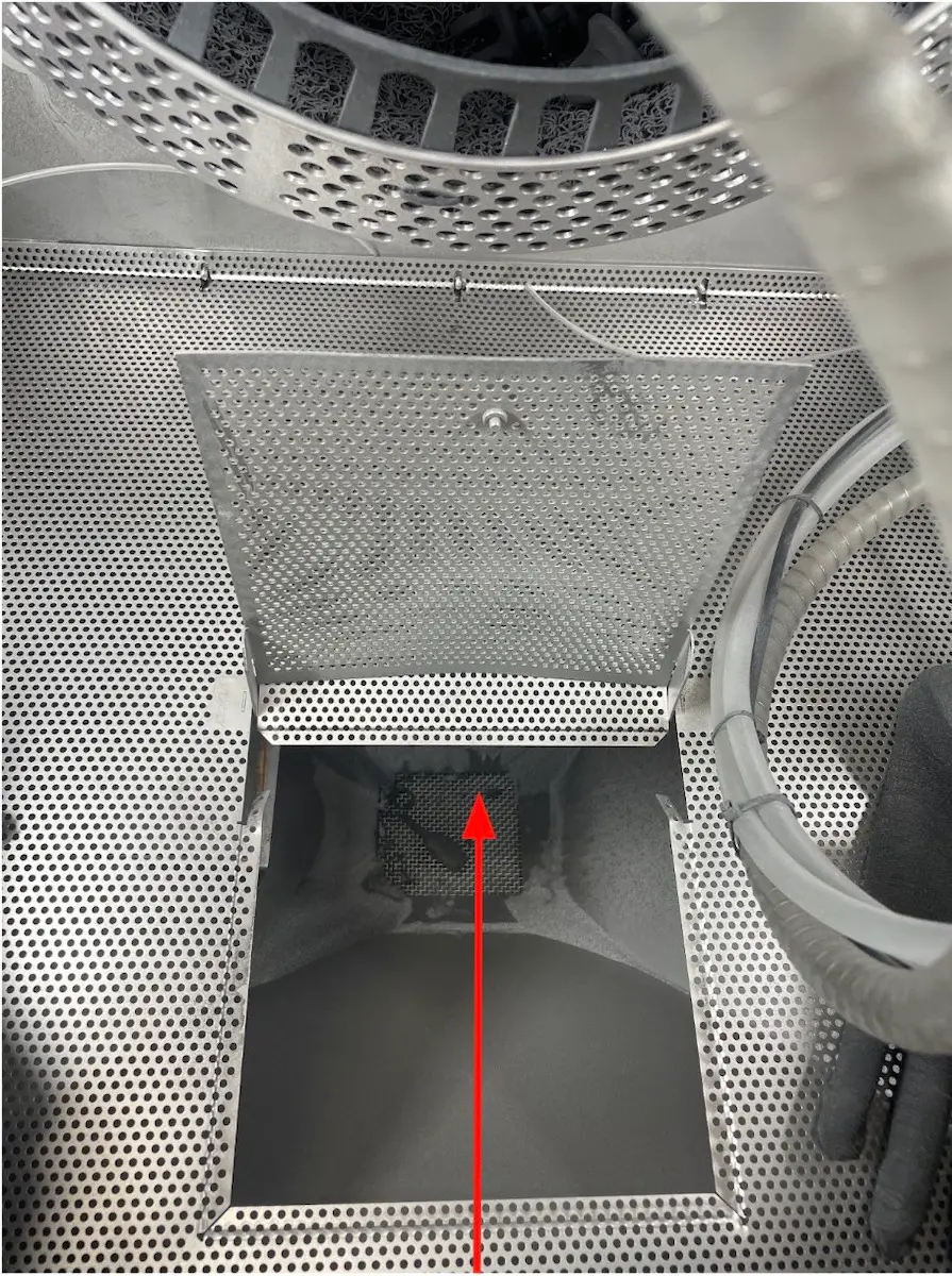 Marked photo of open access hatch in Fuse Blast surface grate showing location of regurgitator line output