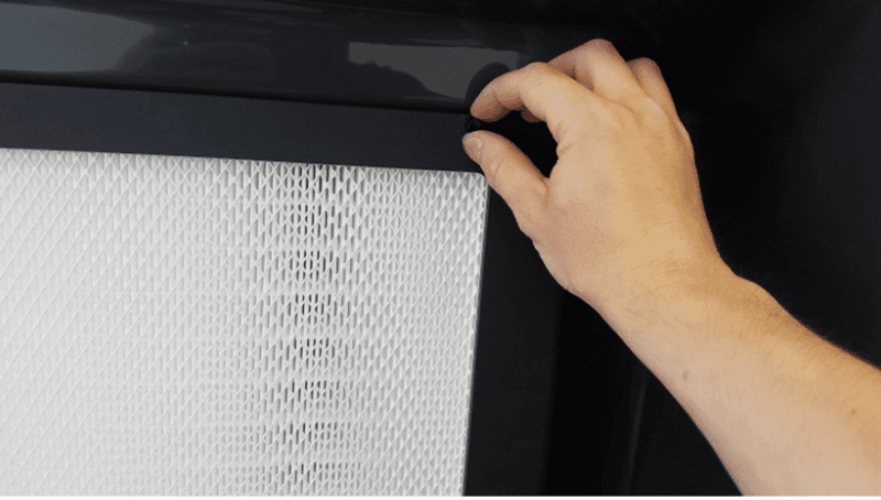 Someone grips a grate thumb screw in preparation to turn