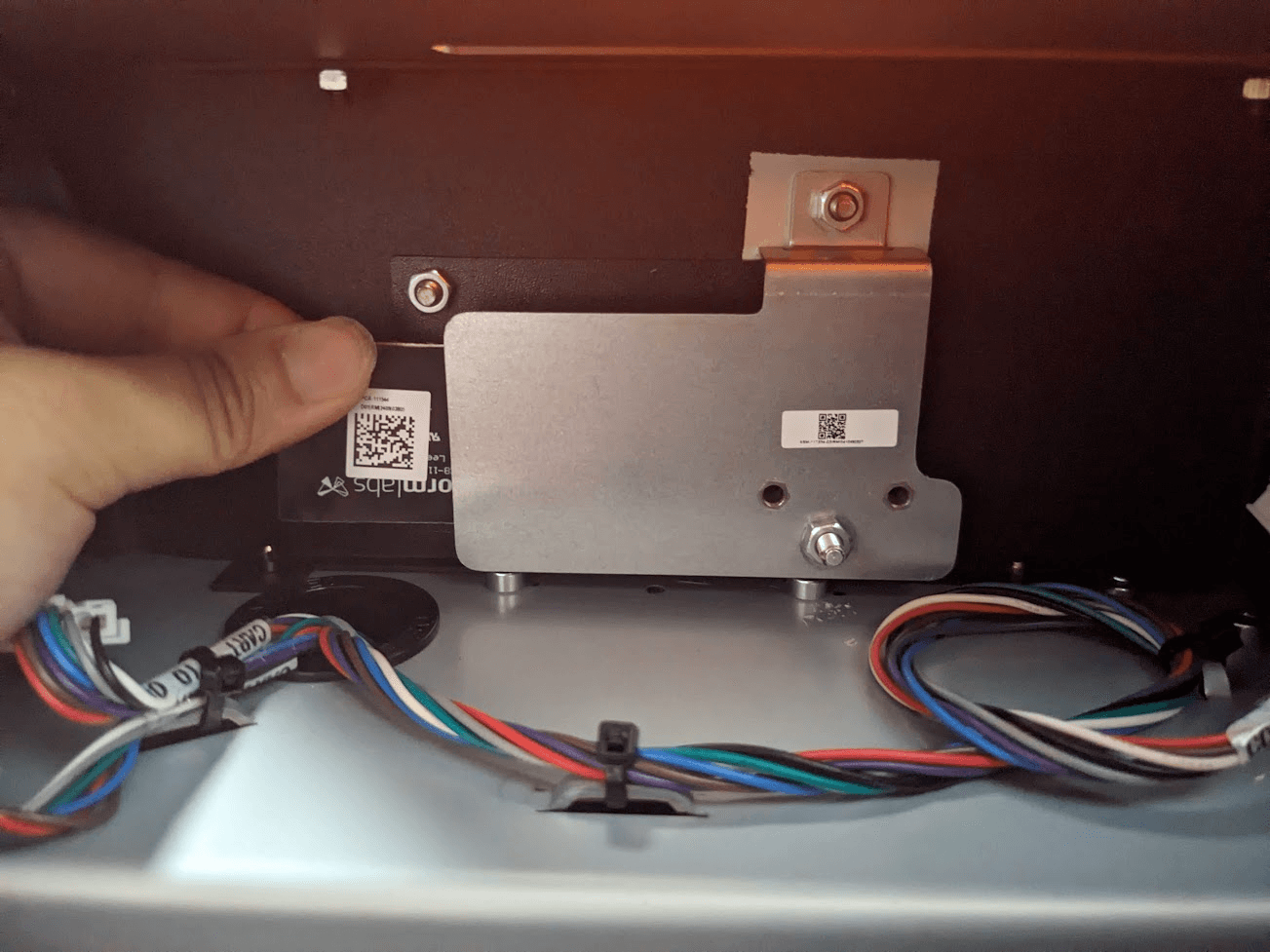 Slide the replacement resin tank RFID board behind the mounting plate.