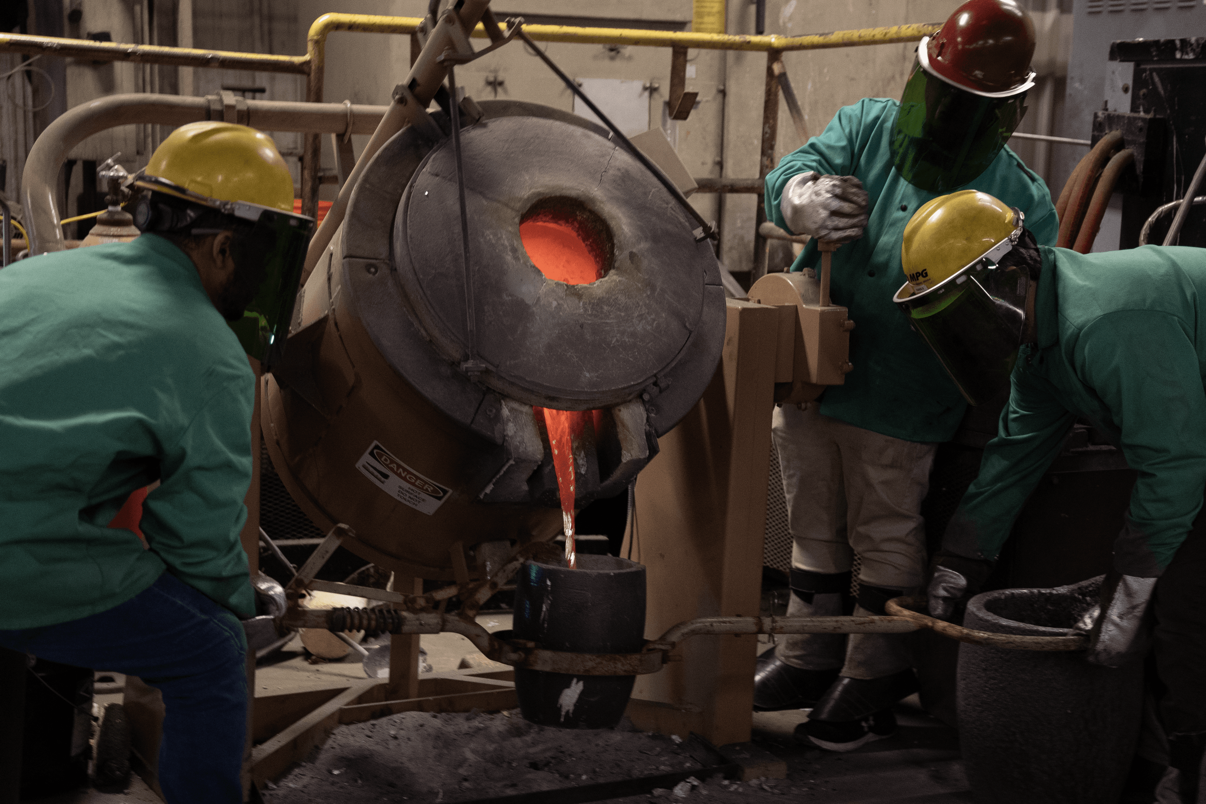 El equipo de la Universidad del Norte de Iowa (UNI) vierte metal de un horno en un crisol