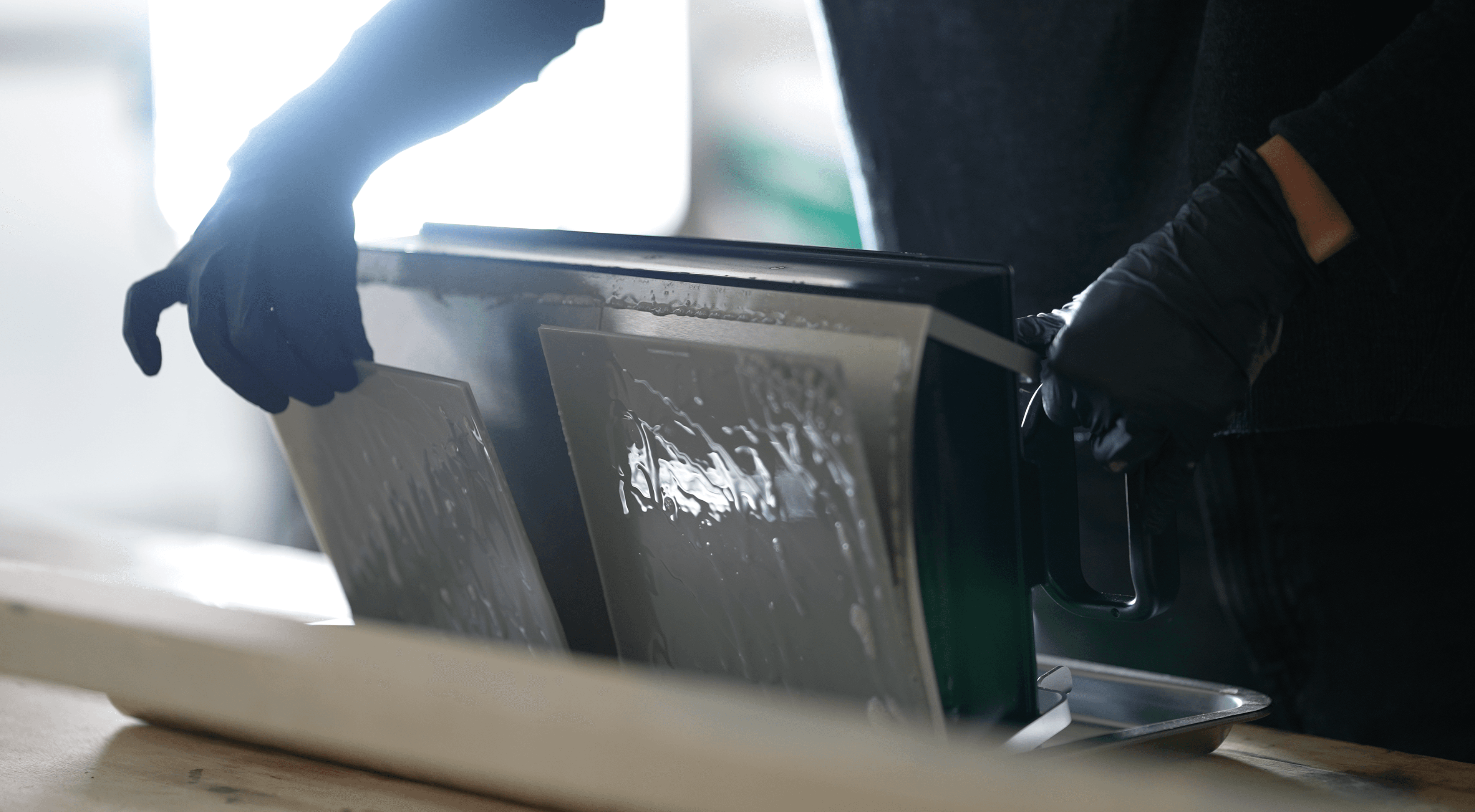 Person wearing gloves removing prints from a Form 4L Flex Build Platform.