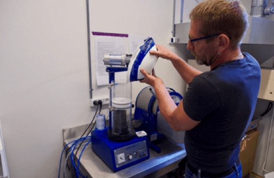 Person mixing investment powder and cold distilled water.