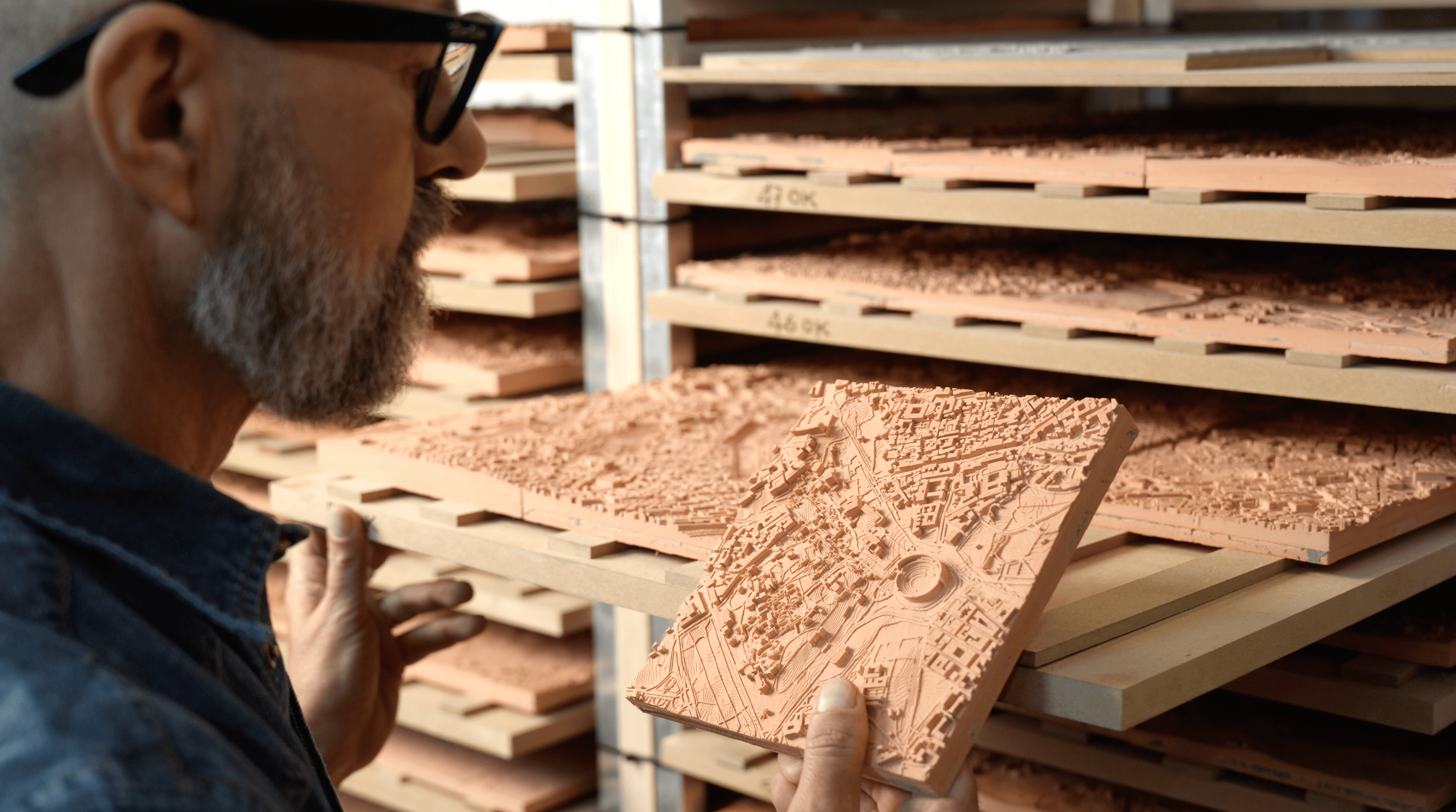 Person looking at highly detailed relief ceramic tile.