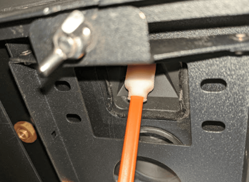 The swab is being inserted into the cavity where the camera lens is