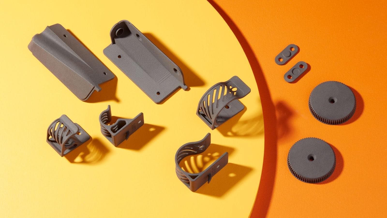sls 3d printed parts on a yellow and orange background