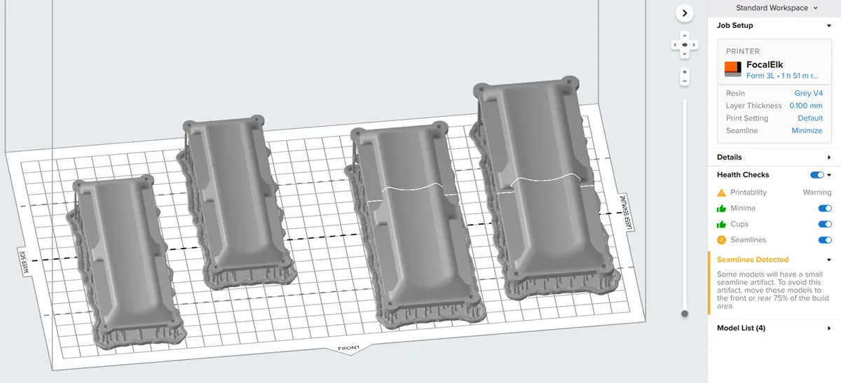 A screenshot of four models on a Form 3L build platform in PreForm. The seamline is visualized in PreForm as a solid line on any part that crosses the 75% of the build platform.