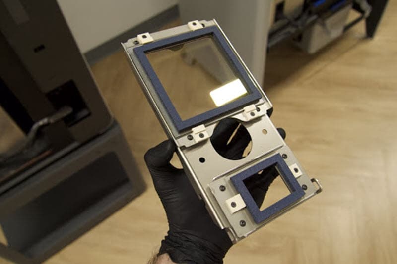 Someone is holding an optical cassette up to the light