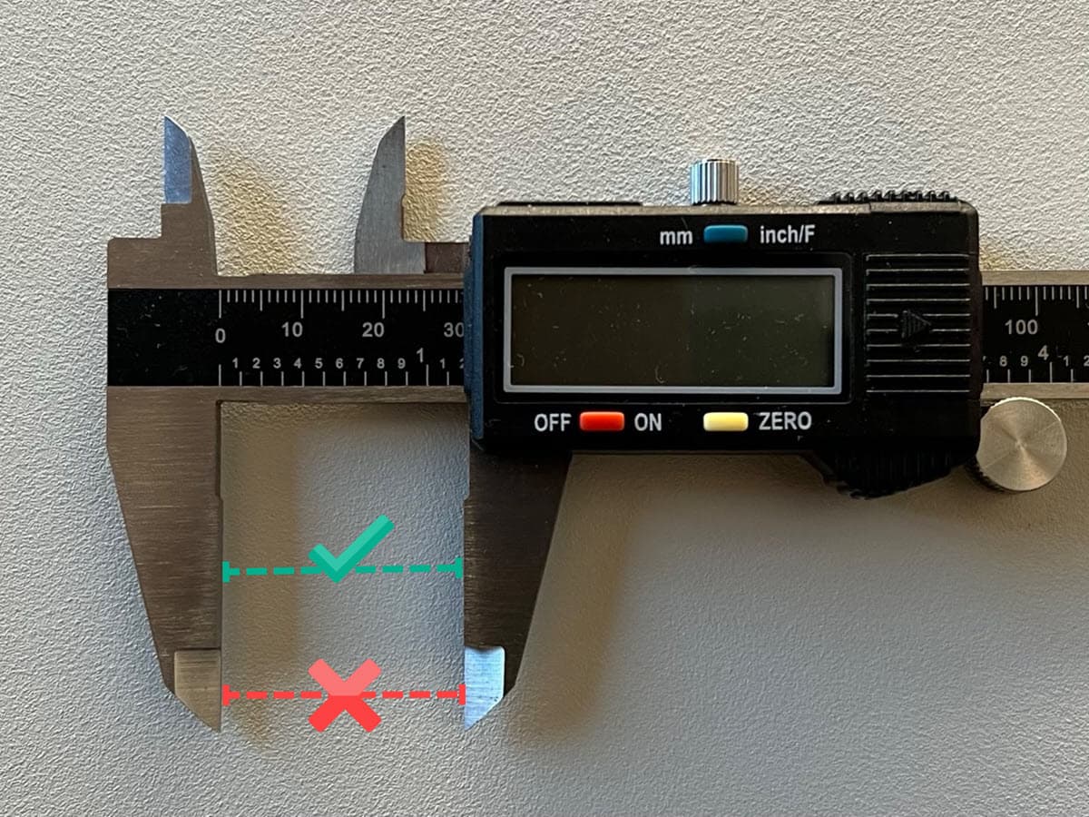 Measure the test print at the flat part of the caliper's lower jaw