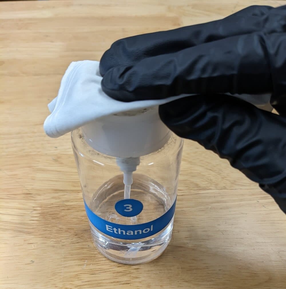 Wetting a microfiber cleaning cloth with ethanol