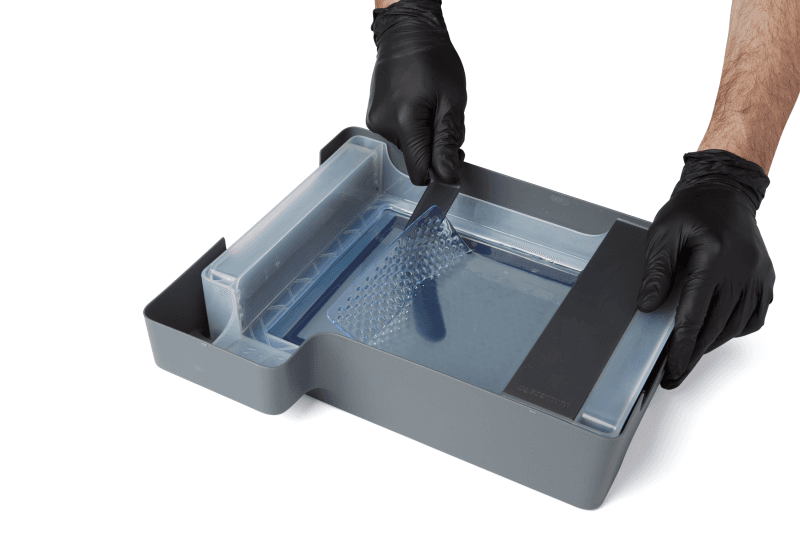 A photo showing the tank tool halfway along the cleaning mesh and being pulled up.