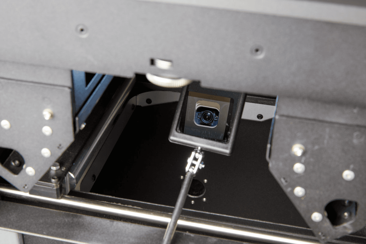 A mirror wand is inserted into the print enclosure, the reflection shows the camera lens