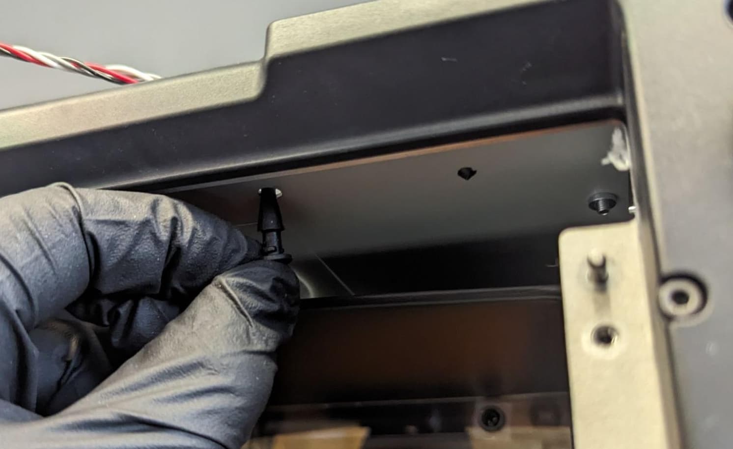 Inserting replacement rubber mounting pins into the lower holes