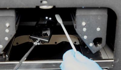 The hand mirror displays the inside of the IR housing while a swab is inserted