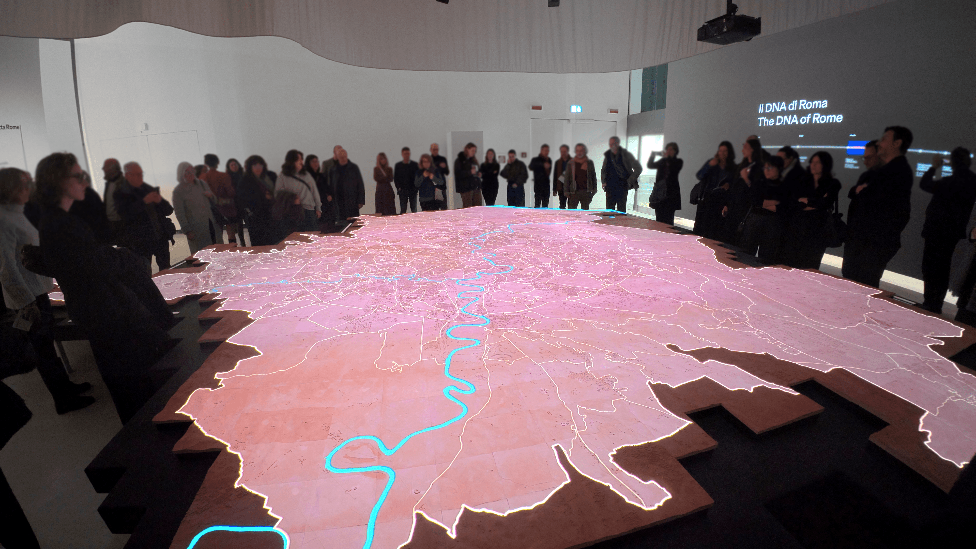 Group of people around map installation with a projected overlay.