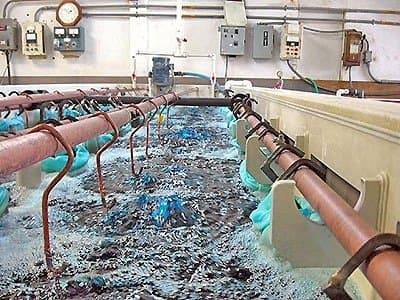 Immersione delle parti mascherate nel bagno galvanico.