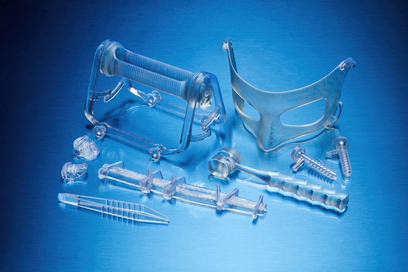 Clear, 3D printed medical devices on a blue background