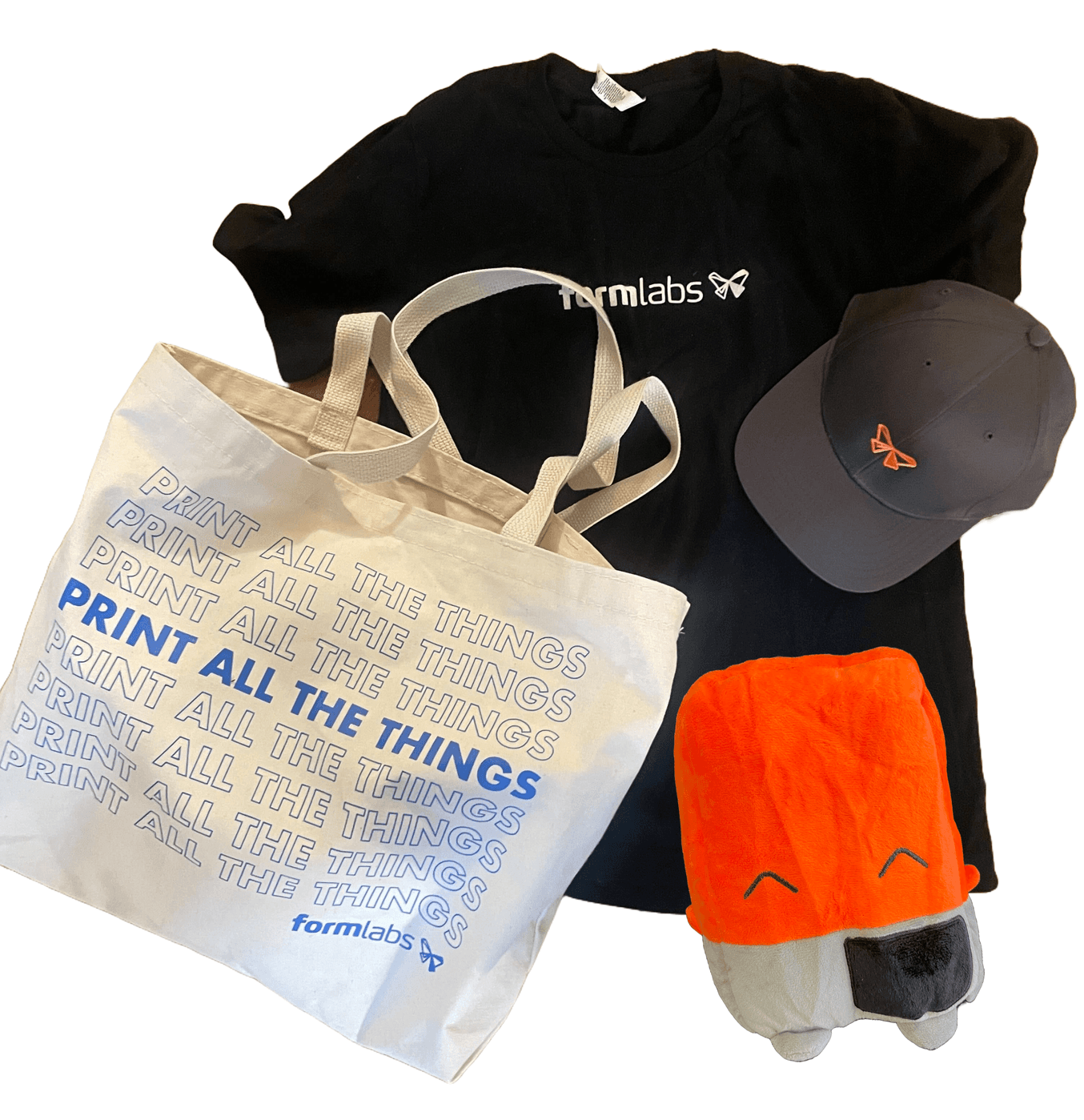 A tote bag, t-shirt, and baseball hat branded with the Formlabs logo along with a plush Form 4