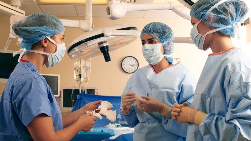 Una dottoressa discute in ospedale con delle colleghe tenendo in mano una parte stampata in 3D.