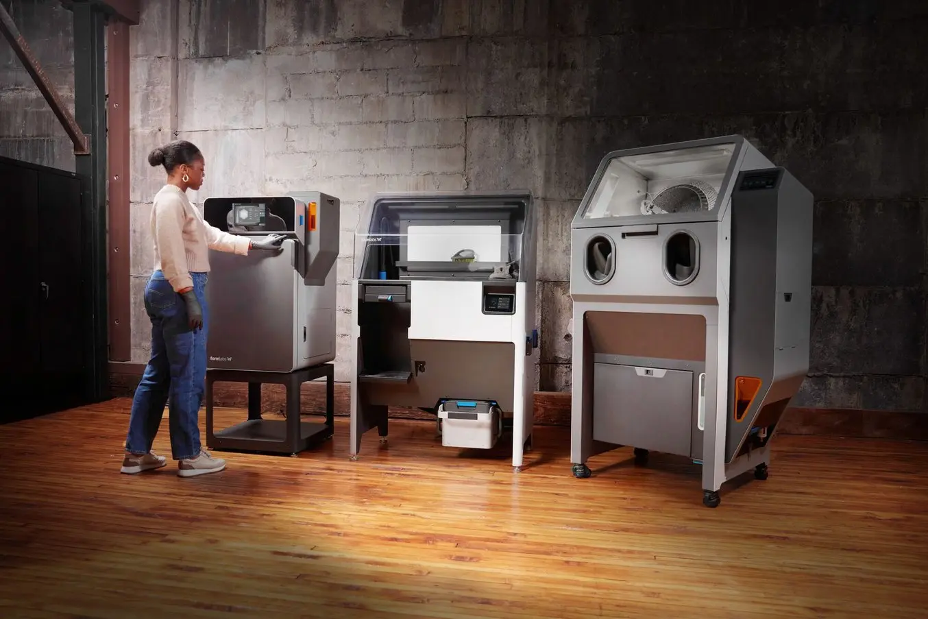 a woman stands in front of the fuse 1+ 30W printer, next to the Fuse Sift and Fuse Blast