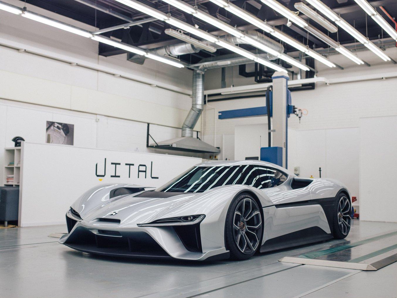 A stylish white concept car in a garage.