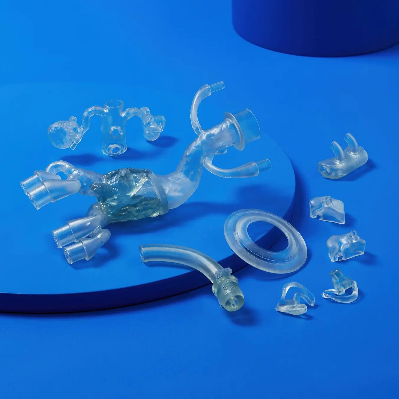 3D printed parts in BioMed Flexible, a clear resin, on a blue background